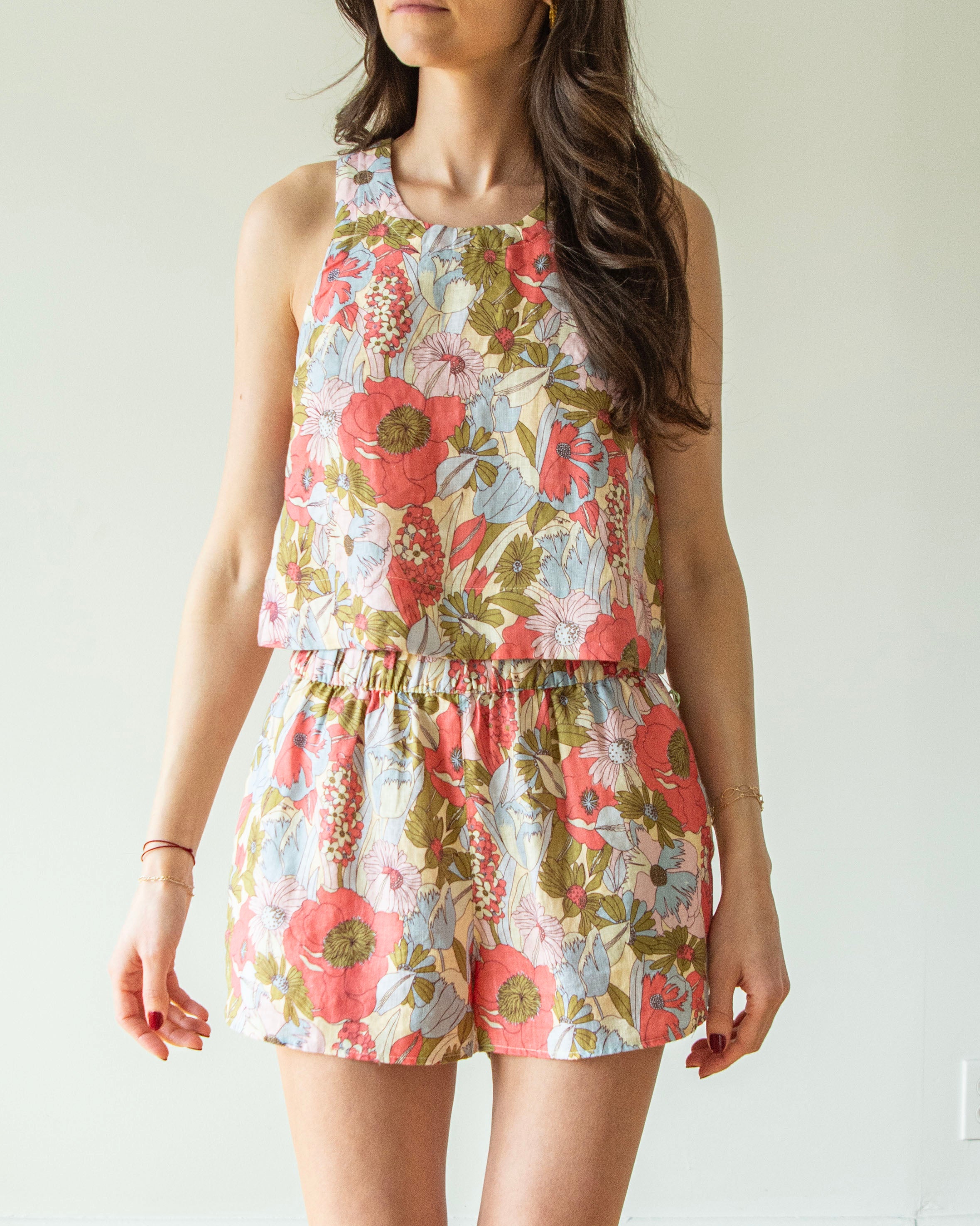 Woman wearing a floral romper against a plain background