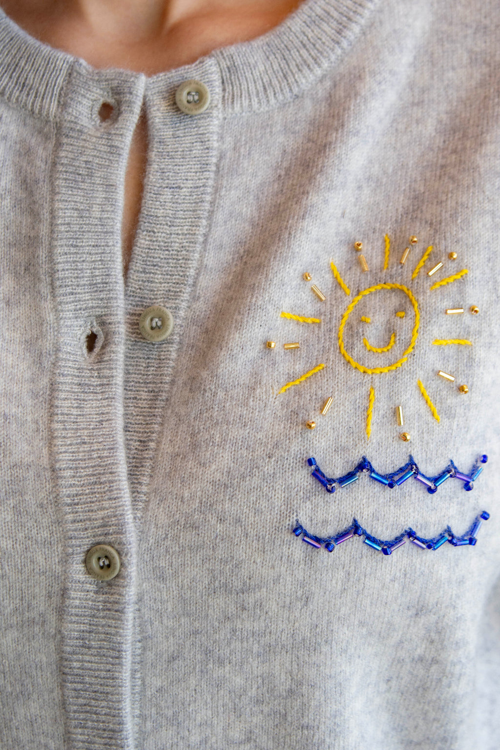 Gray cardigan with embroidered sun and wave design